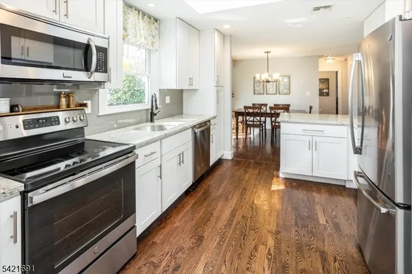 a kitchen with stainless steel appliances a stove a sink and a microwave