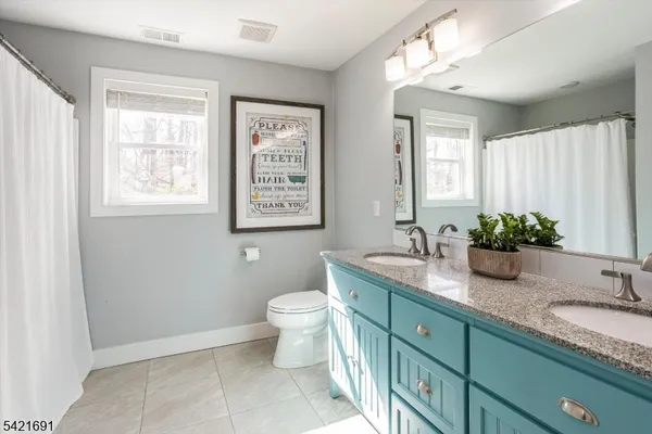 a bathroom with a granite countertop sink mirror vanity and toilet