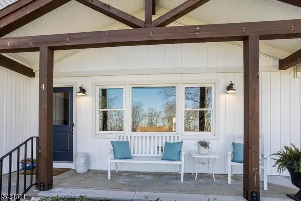 a porch with a chair and potted plant