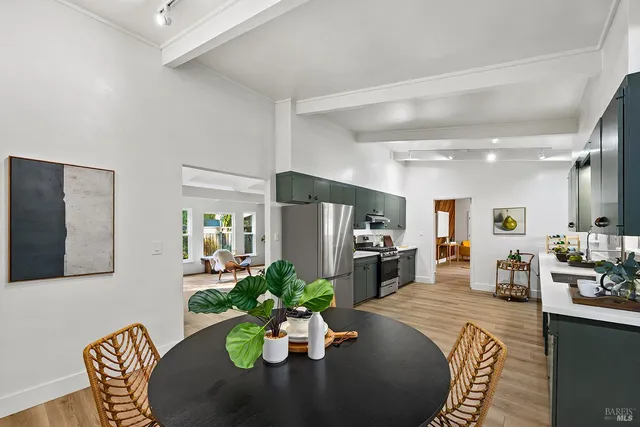 a kitchen with stainless steel appliances a sink dishwasher a stove top oven a refrigerator with wooden floor