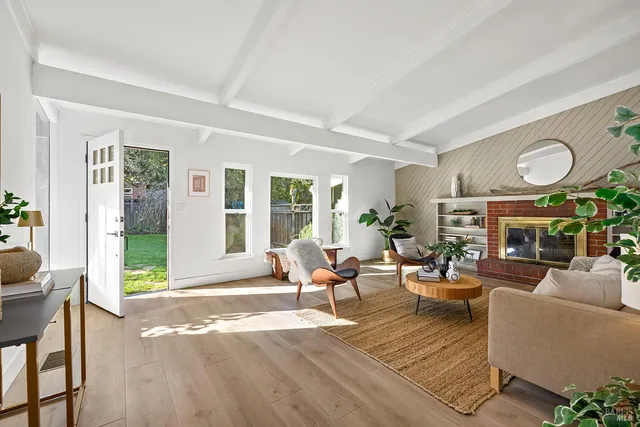 a living room with furniture a fireplace and a large window