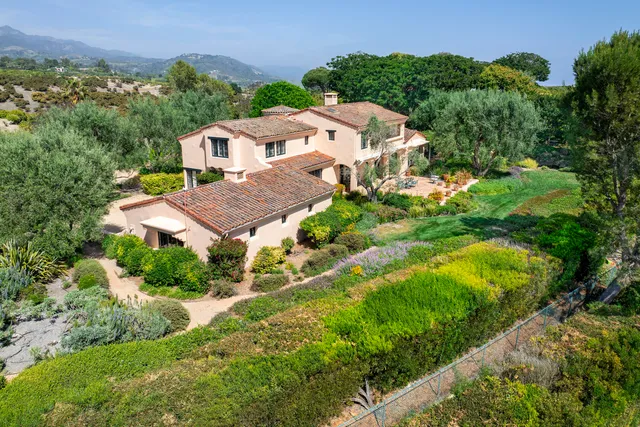 an aerial view of residential houses with outdoor space and trees all around