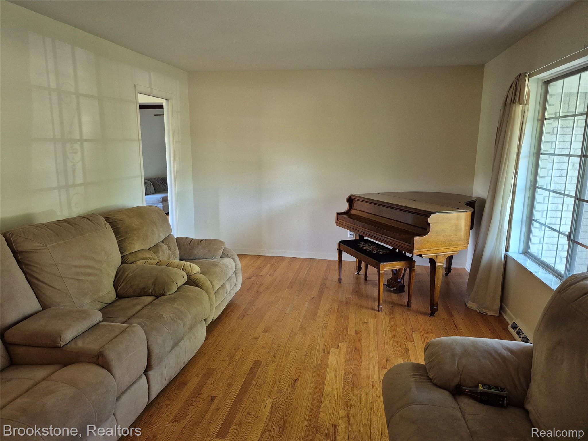 4295 Sashabaw Road Waterford, MI 48329 - Photo 12 of 37 Hardwood flooring extending throughout, complemented by a large window with gridded panes