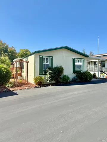 a front view of a house with plants and trees