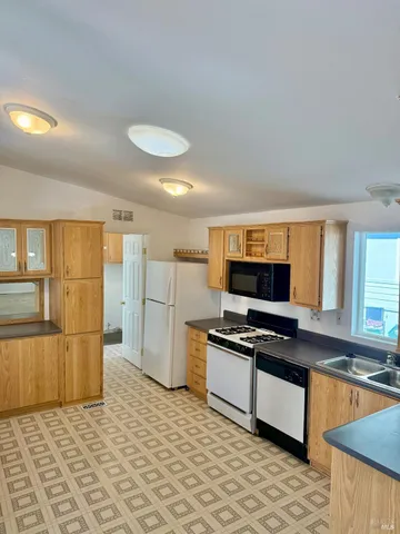 a kitchen with stainless steel appliances granite countertop a stove a sink and a refrigerator