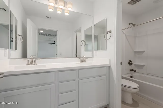 a bathroom with a granite countertop sink a toilet and a mirror