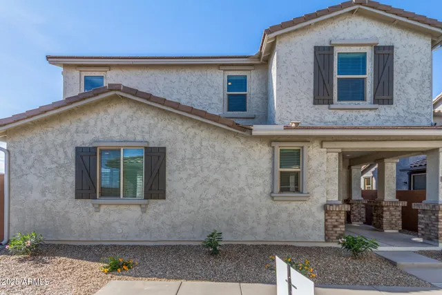 a front view of a house with plants