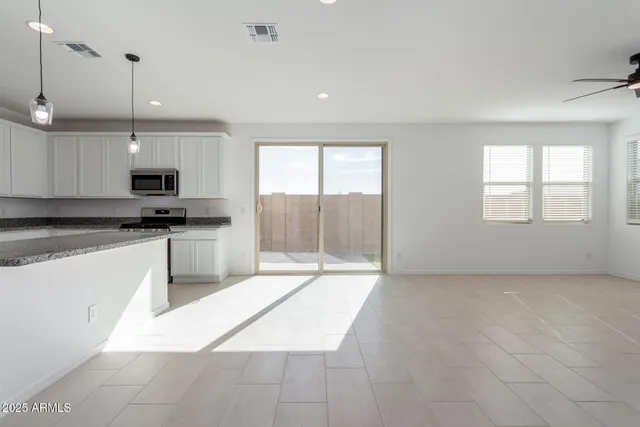 a kitchen with granite countertop a stove a sink and a microwave