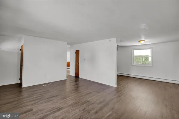 an empty room with wooden floor and a window
