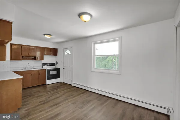 a large kitchen with a large window a sink and stainless steel appliances
