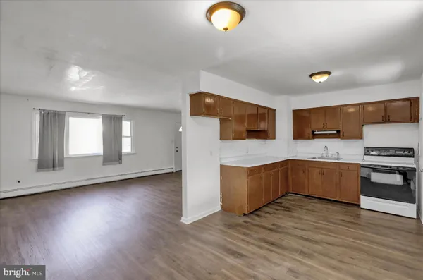 a kitchen with stainless steel appliances granite countertop a sink a stove top oven and wooden floors