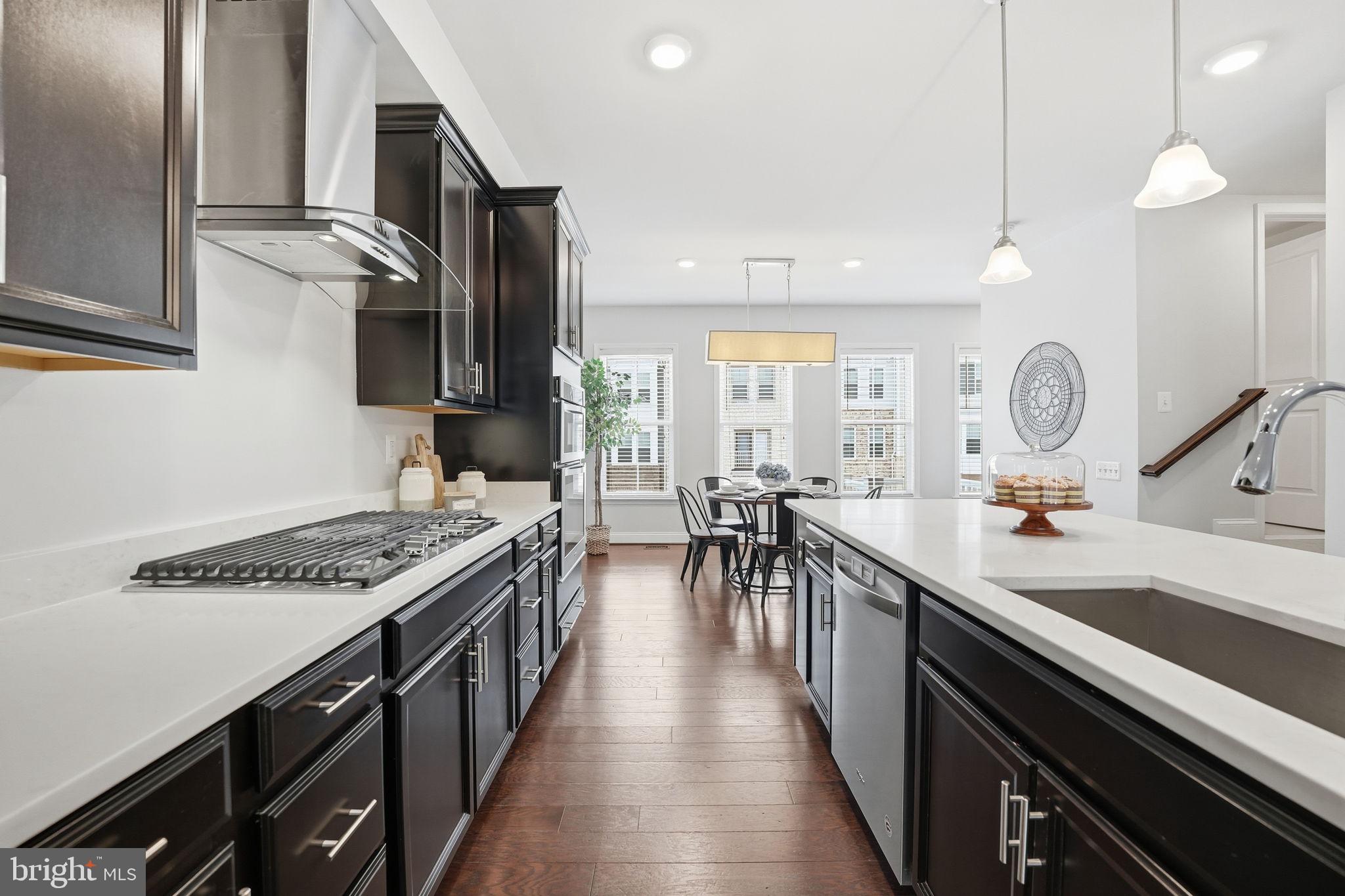 17354 Redshank Road Dumfries, VA 22026 - Photo 12 of 65 a kitchen with stainless steel appliances granite countertop a stove a sink dishwasher and cabinets with wooden floor