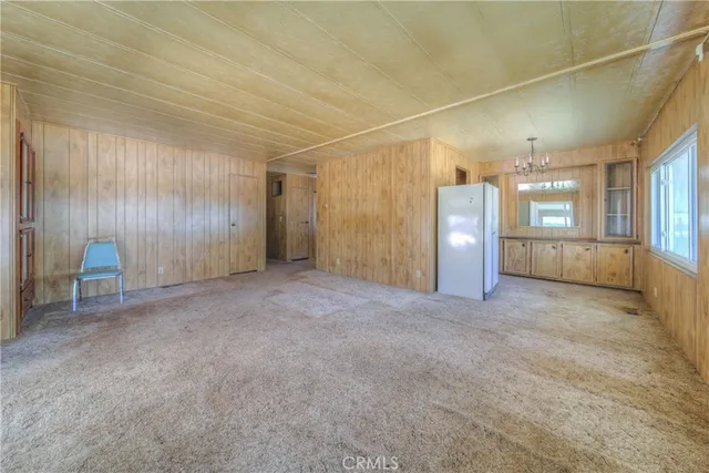 an empty room with a ceiling fan and a window