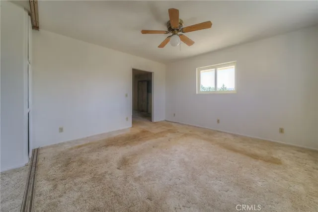 a view of an empty room with a fireplace and a window