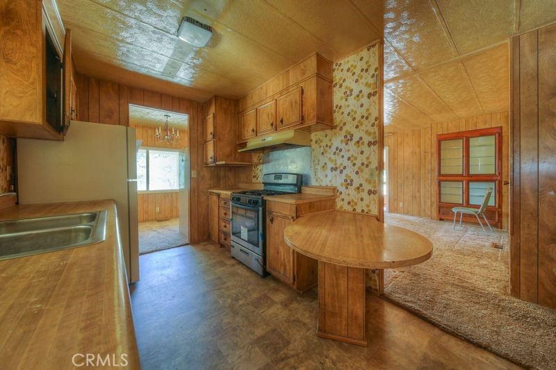 55743 Mitchell Road Anza, CA 92539 - Photo 30 of 46 a kitchen with stainless steel appliances granite countertop a sink a stove and a wooden floors