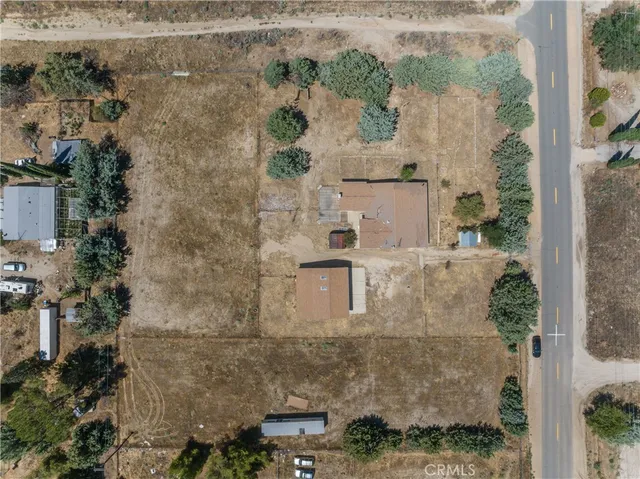 an aerial view of residential houses with outdoor space and trees