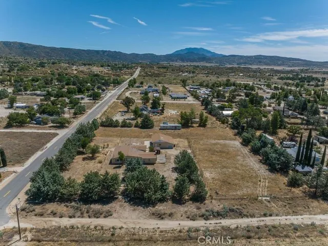 an aerial view of a house with yard and lake view