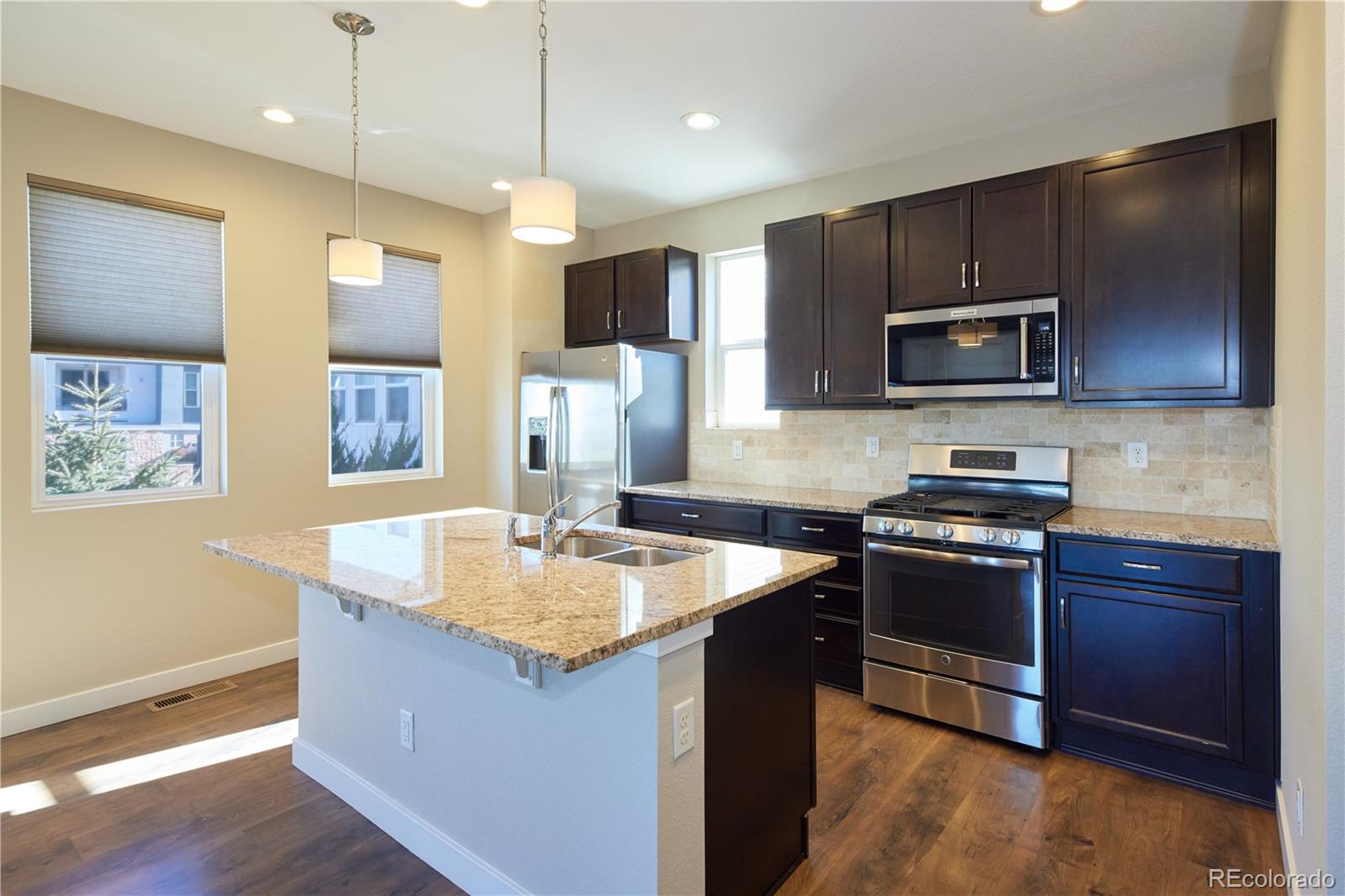 11225 Colony Row Broomfield, CO 80021 - Photo 6 of 31 a kitchen with stainless steel appliances granite countertop a sink stove and refrigerator