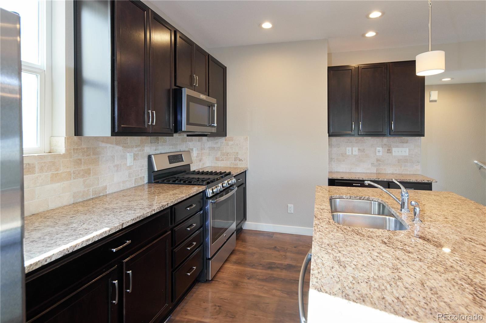 11225 Colony Row Broomfield, CO 80021 - Photo 8 of 31 a kitchen with stainless steel appliances granite countertop sink microwave and stove