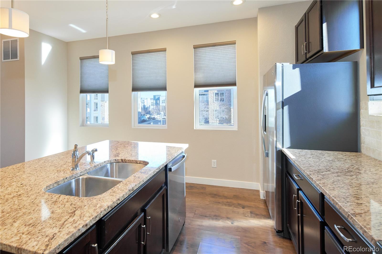 11225 Colony Row Broomfield, CO 80021 - Photo 9 of 31 a kitchen with granite countertop a sink a counter top space and cabinets