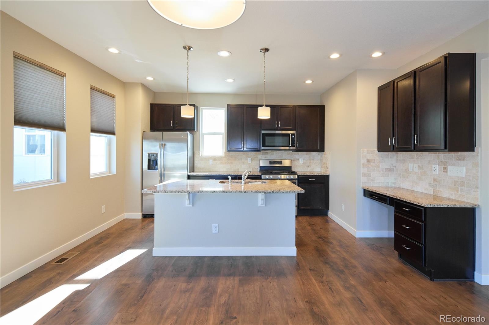 11225 Colony Row Broomfield, CO 80021 - Photo 10 of 31 a large kitchen with stainless steel appliances granite countertop a stove and a wooden floors