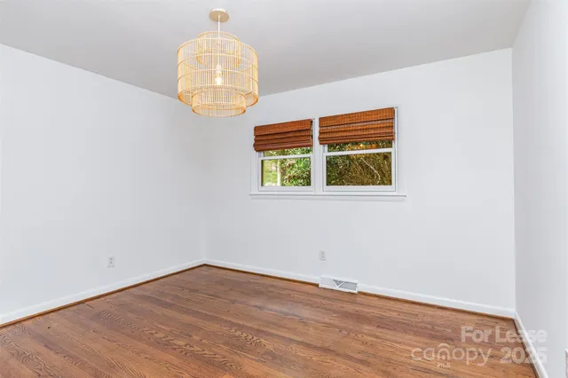 an empty room with wooden floor and a window