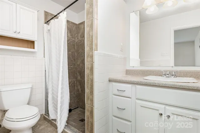 a bathroom with a granite countertop sink toilet and shower