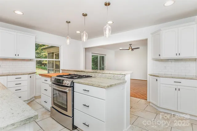 a kitchen with granite countertop white cabinets and white appliances