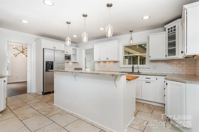 a kitchen with stainless steel appliances granite countertop a refrigerator sink and cabinets