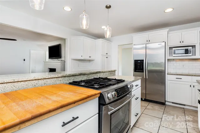 a kitchen with stainless steel appliances granite countertop a stove and a refrigerator