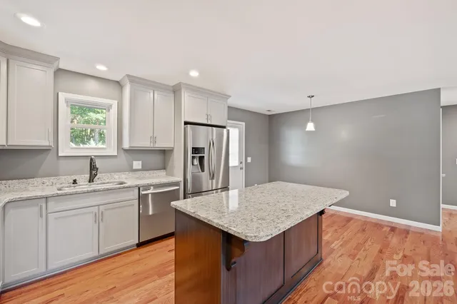 a kitchen with a sink a refrigerator and cabinets