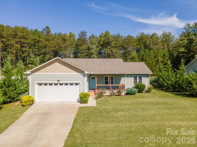 a view of a house with a yard and trees