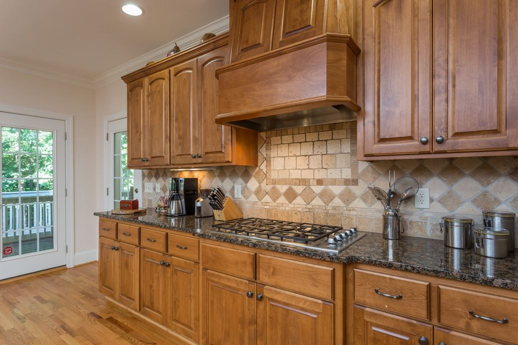7220 Sunset Glen Point Raleigh, NC 27614 - Photo 6 of 25 Granite countertops, XL island, gas stove top and separate wall oven are just some of the grand features in the kitchen. Kitchen