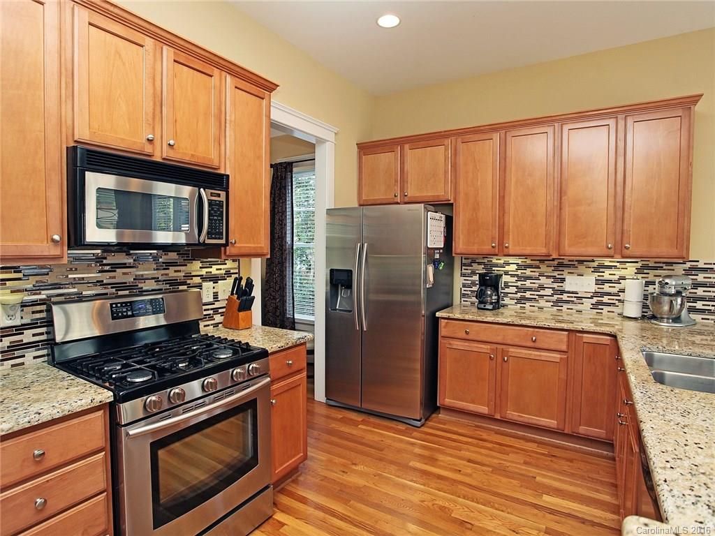 1865 2nd Baxter Crossing Fort Mill, SC 29708 - Photo 10 of 24 a kitchen with granite countertop wooden cabinets and stainless steel appliances