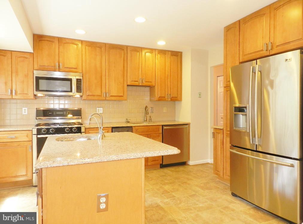 a kitchen with stainless steel appliances a refrigerator a stove a microwave a sink and cabinets