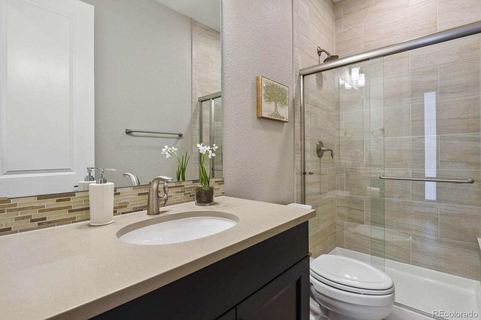 76 Niagara Street Denver, CO 80230 - Photo 11 of 44 a bathroom with a sink a toilet and shower