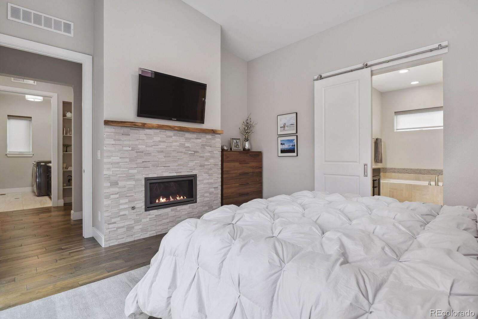 76 Niagara Street Denver, CO 80230 - Photo 14 of 44 a spacious bedroom with a bed and a fireplace