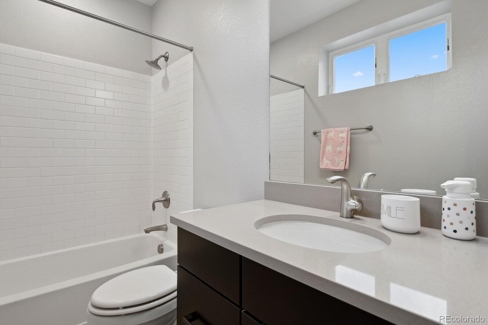 76 Niagara Street Denver, CO 80230 - Photo 21 of 44 a bathroom with a granite countertop sink toilet a mirror and shower