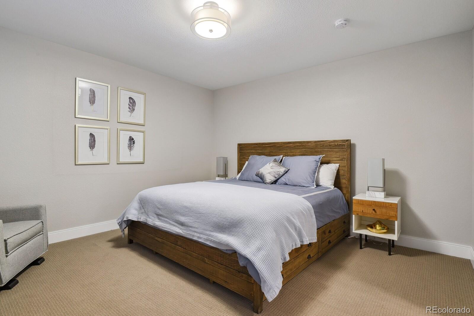 76 Niagara Street Denver, CO 80230 - Photo 28 of 44 a large bed sitting in a bedroom next to a lamp