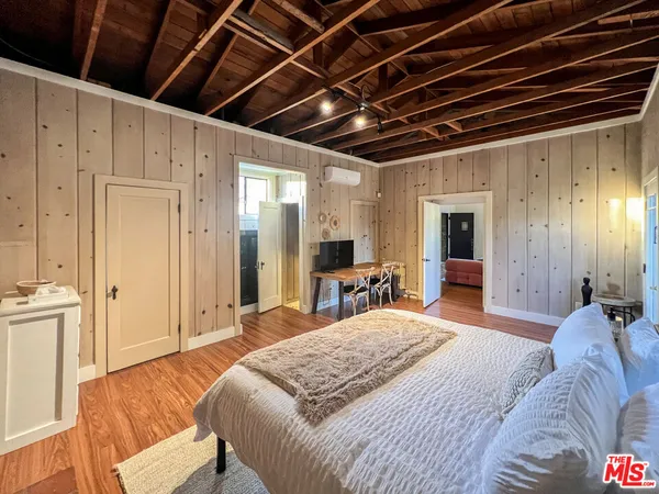 a bedroom with furniture and a flat screen tv
