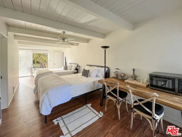 a bedroom with a large bed and a flat tv screen on dresser