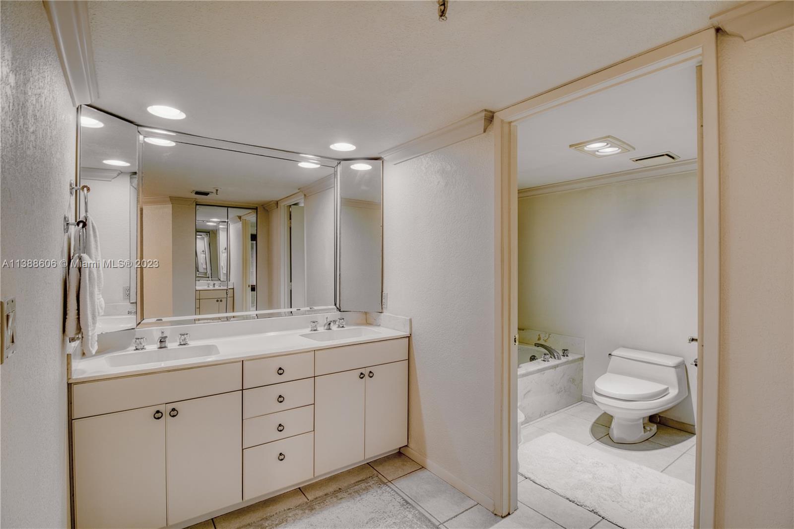 520 Brickell Key Drive, Unit A810 Miami, FL 33131 - Photo 17 of 20 a spacious bathroom with a granite countertop sink toilet and a mirror