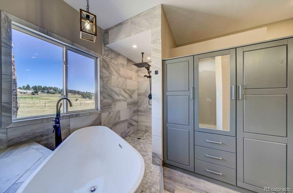 14965 Tanner Trail Elbert, CO 80106 - Photo 16 of 40 a bathroom with a bathtub and shower