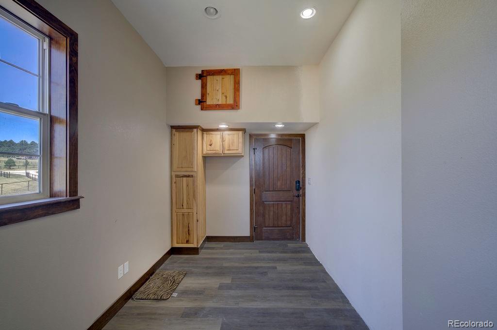 14965 Tanner Trail Elbert, CO 80106 - Photo 20 of 40 a view of a hallway with wooden floor and a bathroom