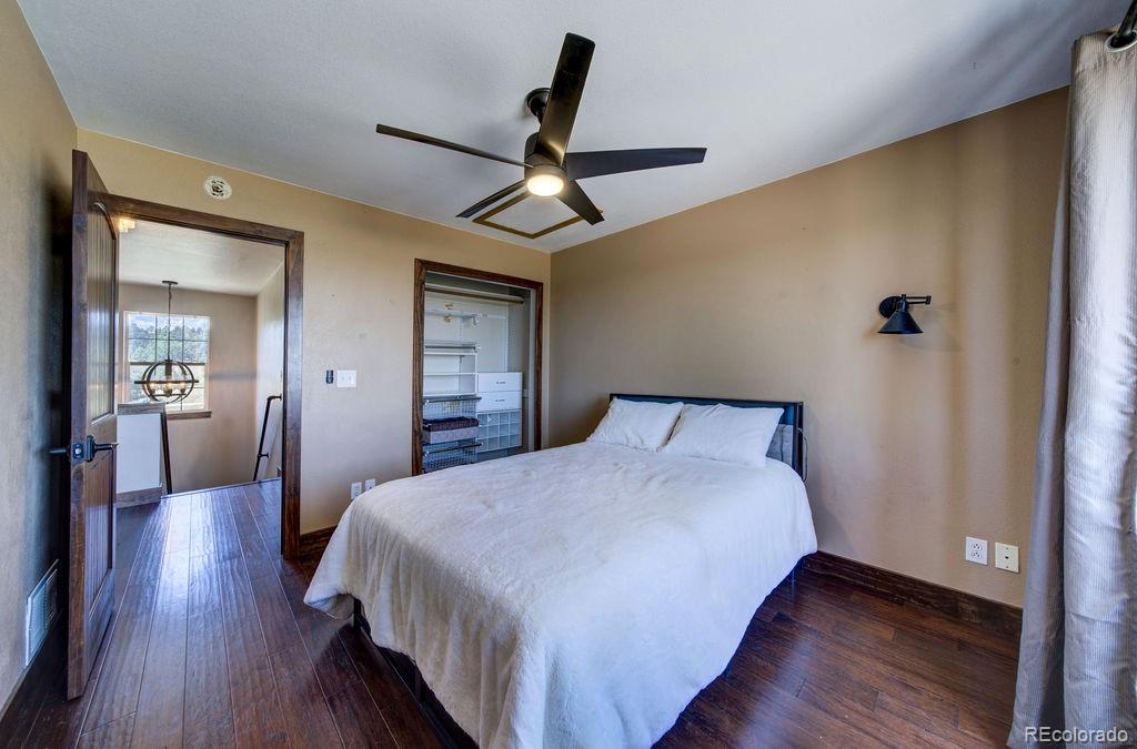 14965 Tanner Trail Elbert, CO 80106 - Photo 22 of 40 a bedroom with a bed and wooden floor