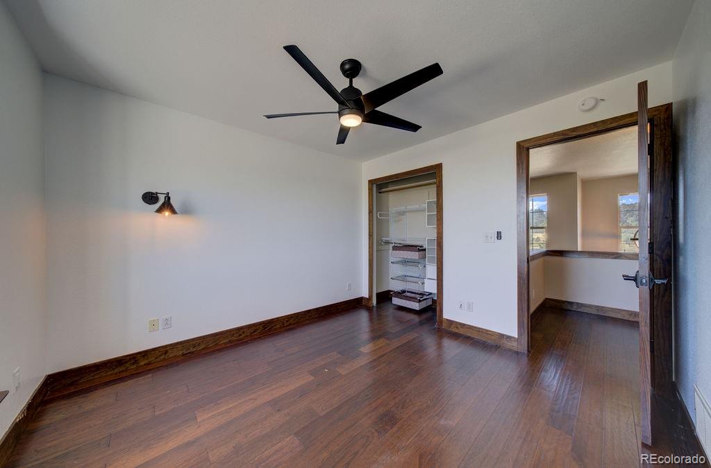 14965 Tanner Trail Elbert, CO 80106 - Photo 24 of 40 an empty room with wooden floor and a ceiling fan