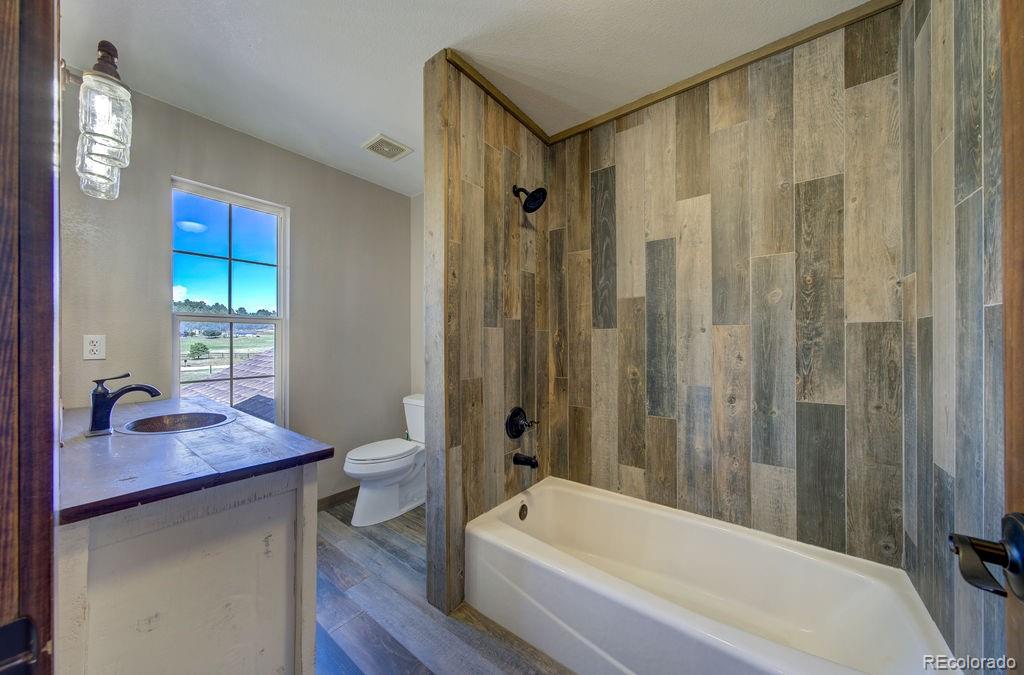 14965 Tanner Trail Elbert, CO 80106 - Photo 25 of 40 a bathroom with a granite countertop sink toilet and shower