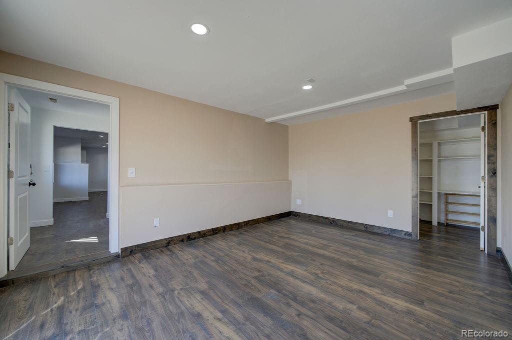 14965 Tanner Trail Elbert, CO 80106 - Photo 27 of 40 an empty room with wooden floor & bathroom