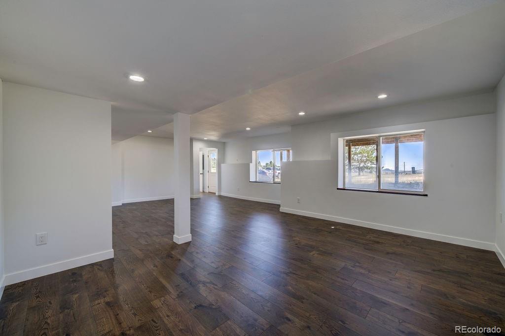 14965 Tanner Trail Elbert, CO 80106 - Photo 29 of 40 an empty room with wooden floor and windows