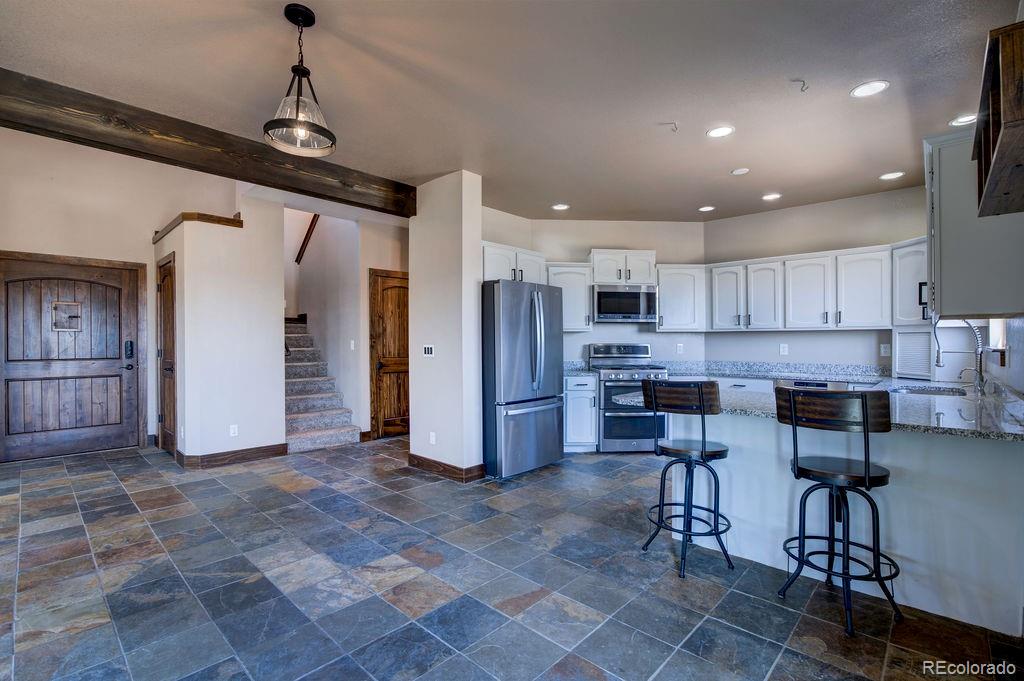 14965 Tanner Trail Elbert, CO 80106 - Photo 7 of 40 a kitchen with stainless steel appliances granite countertop a refrigerator and a stove top oven